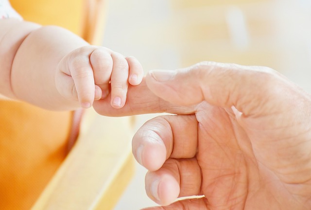 Babyhand hält Hand eines Erwachsenen